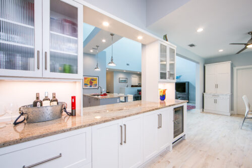 This is a picture of the side-view of a white kitchen with custom white cabinetry by Kountry Kraft Custom Cabinetry. 