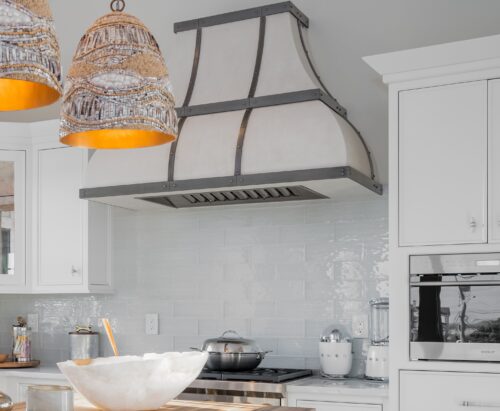 This is a picture of a stone kitchen range hood featured in a kitchen with custom made cabinetry by Kountry Kraft Cabinetry.