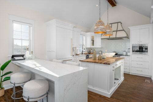 This is a picture of an overview of a white kitchen in Avalon New Jersey with custom-made cabinetry by Konutry Kraft Cabinetry. 