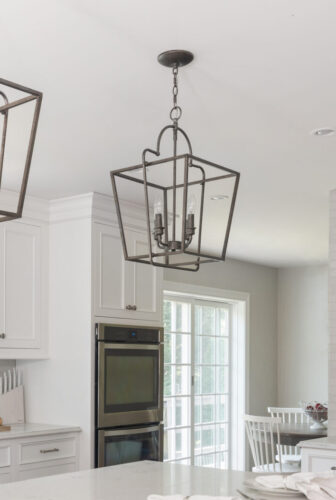 This is a picture of a white kitchen and honey brown wood flooring with custom cabinets from Kountry Kraft Cabinetry.