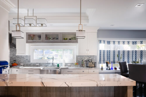 This is a picture of a white and silver kitchen in Great Neck New York with custom cabinetry from Kountry Kraft Cabinetry. 