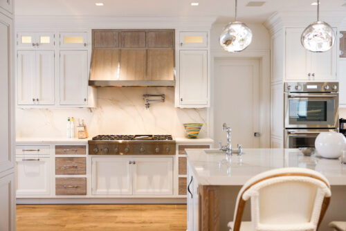 This is a picture of the range hood and white backsplash of a custom kitchen in Remsenburg New York with cabinetry by Kountry Kraft Cabinetry. 