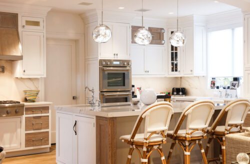 This is a picture of the contrasting cabinetry colors with a white kitchen island from a kitchen in Remsenburg New York. 
