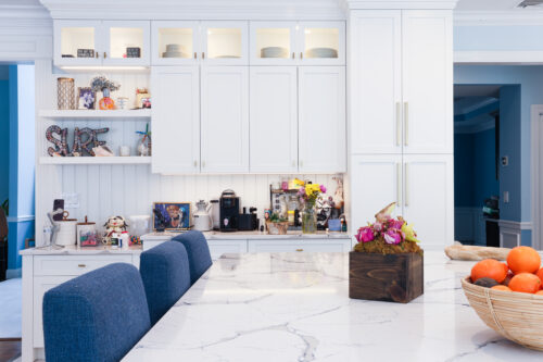A kitchen with white cabinets manufactured by Kountry Kraft Cabinetry.