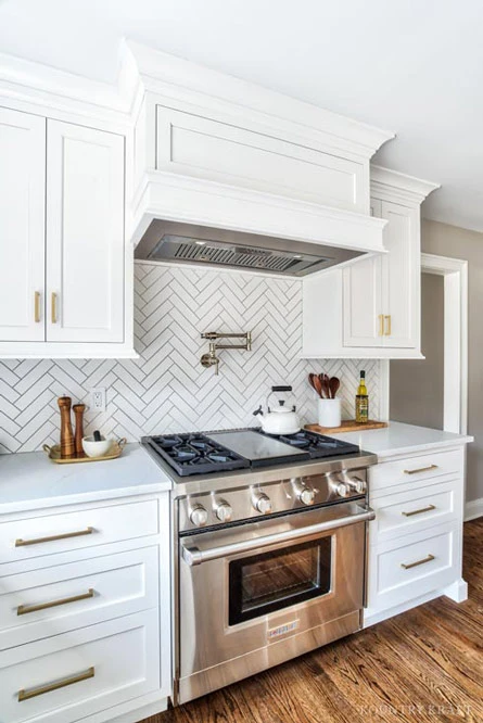 Alpine White Cabinets with Matching Custom Range Hood and Chevron Tile Backsplash in New Jersey