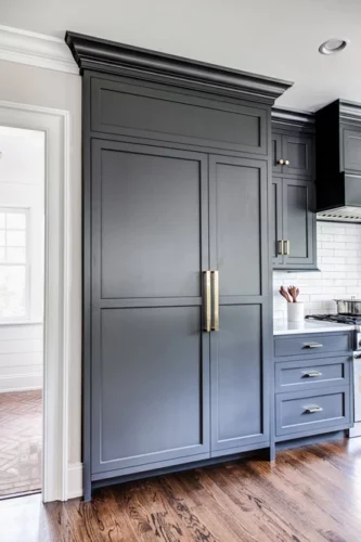A black closed panel fridge by Kountry Kraft Cabinetry.