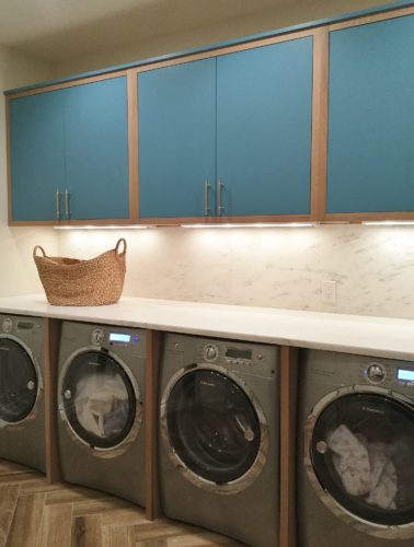 this custom laundry room features custom closets and cabinetry