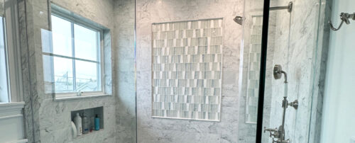 This is a picture of the custom made glass shower mosaic with a range of grays, whites, and blues. 