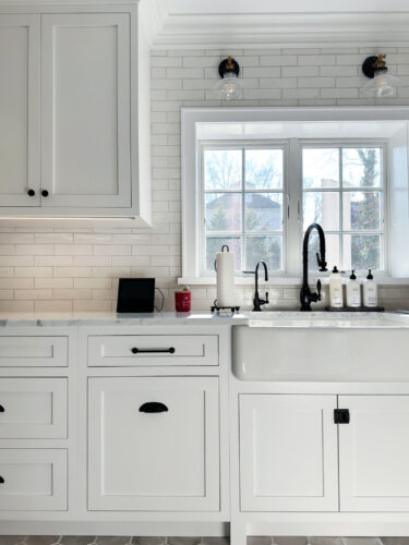 This is a picture of the white kitchen cabinets and sink with custom cabinetry by Kountry Kraft Cabinetry. 