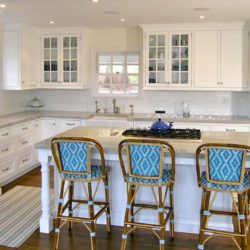 White L-shaped kitchen with ovens, island, cooktop, and four chairs Greenwich, CT