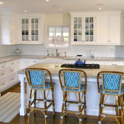 White L-shaped kitchen with ovens, island, cooktop, and four chairs Greenwich, CT