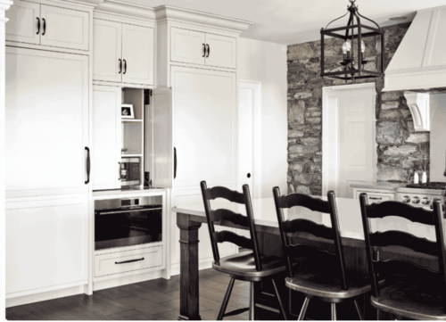 This Lebanon, PA kitchen remodel transforms a home with Kountry Kraft’s Penn Line custom cabinetry, finished in Benjamin Moore Hush AF-95. The kitchen blends classic design with modern functionality, featuring a large custom range hood over a Wolf double range, a vibrant blue butler’s pantry, and a spacious island seating six