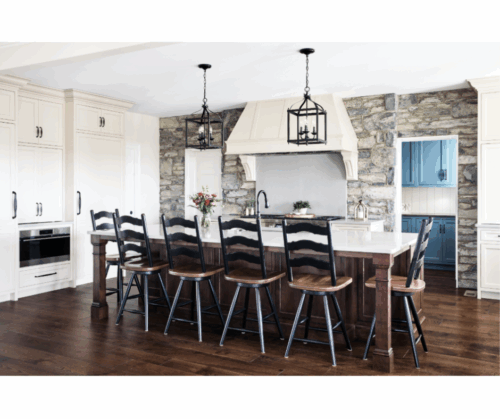 This Lebanon, PA kitchen remodel transforms a home with Kountry Kraft’s Penn Line custom cabinetry, finished in Benjamin Moore Hush AF-95. The kitchen blends classic design with modern functionality, featuring a large custom range hood over a Wolf double range, a vibrant blue butler’s pantry, and a spacious island seating six