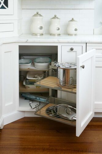 This is a photo of an ergonomic pull-out lazy susan style cabinet made by Kountry Kraft Custom Cabinetry.