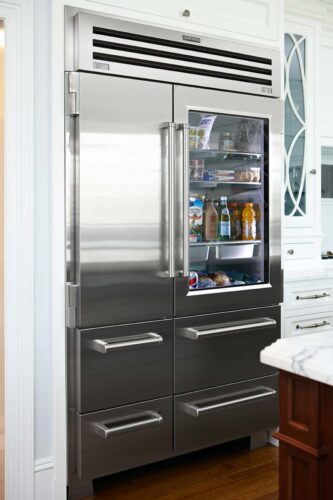 This is a picture of a silver fridge and custom made freezer by Sub-Zero.