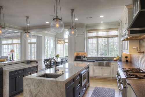 This is a picture of the gray countertop and island of a kitchen featuring custom cabinetry from Kountry Kraft Cabinetry. 