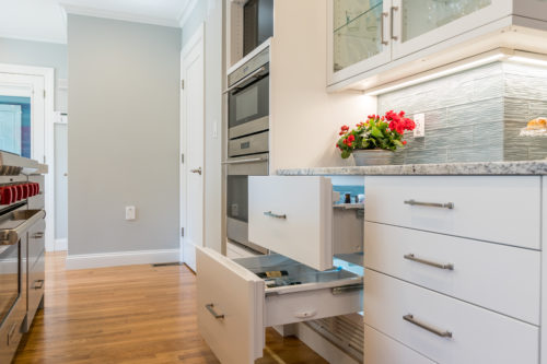 U Shaped Kitchen Featuring Custom Painted White Cabinetry with Silver Pulls as Hardware