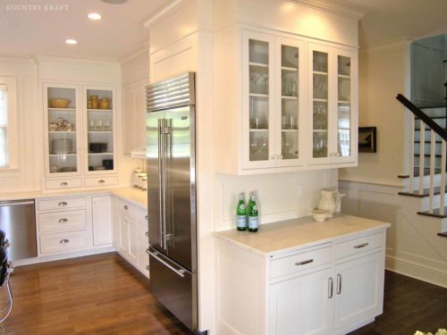 White U-shaped kitchen with stainless steel refrigerator and glass panel cabinetry Darien, CT