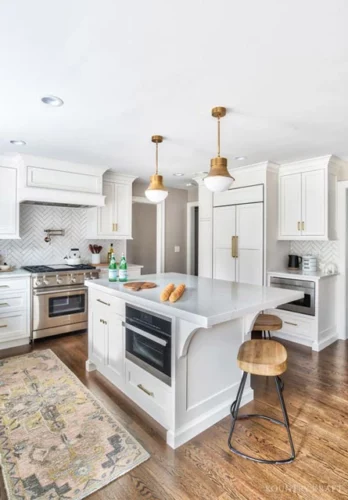 White Kitchen Cabinets with Stainless Steel appliances wood floors and brass fixtures