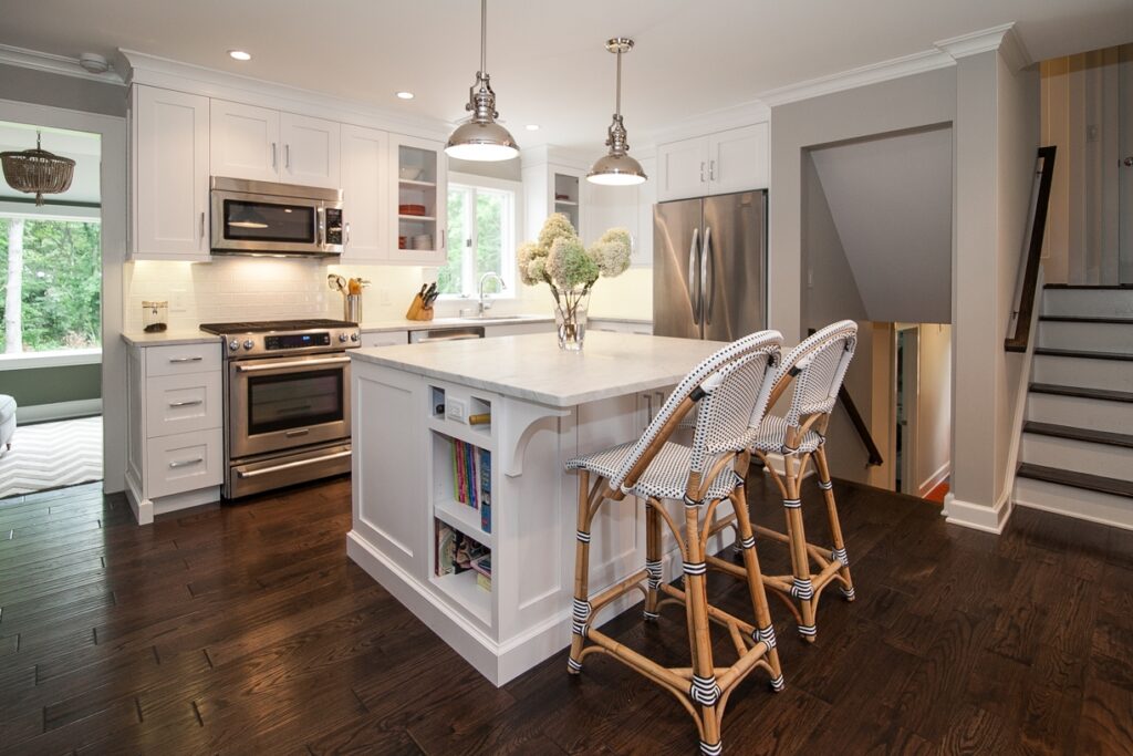 This is a picture of a custom made white kitchen with dark wood floors and cabinetry made by Kountry Kraft Cabinetry.