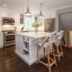 This is a picture of a custom made white kitchen with dark wood floors and cabinetry made by Kountry Kraft Cabinetry.