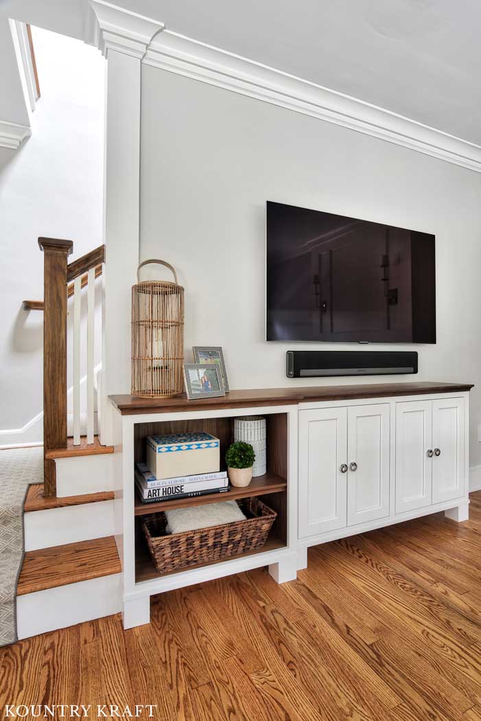 Alpine White Cabinetry and Walnut wood top and shelves for an entertainment center in Summit, New Jersey