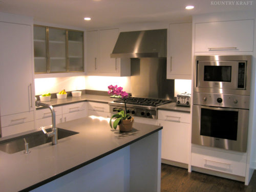 Modern white kitchen cabinetry, range, oven, and island with sink New Canaan, CT