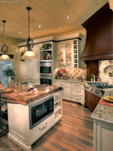 Custom kitchen cabinetry, island with built in microwave, and elegant range