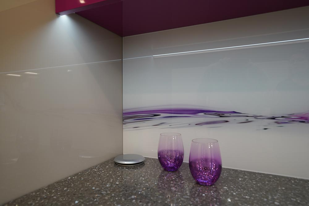 purple glass backsplash with purple accent items