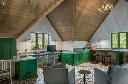 Wide view of craft room and home office with custom cabinets in Haverford PA, featuring green cabinetry, patterned tile, and vaulted wood ceiling.