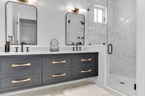 Modern master bathroom with custom bathroom cabinets in Sea Isle City NJ featuring dark painted cabinetry and marble finishes