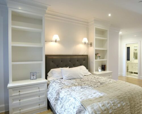 Close-up of bookcase tower with drawer stack beside bed; custom bedroom cabinets in Annapolis MD.
