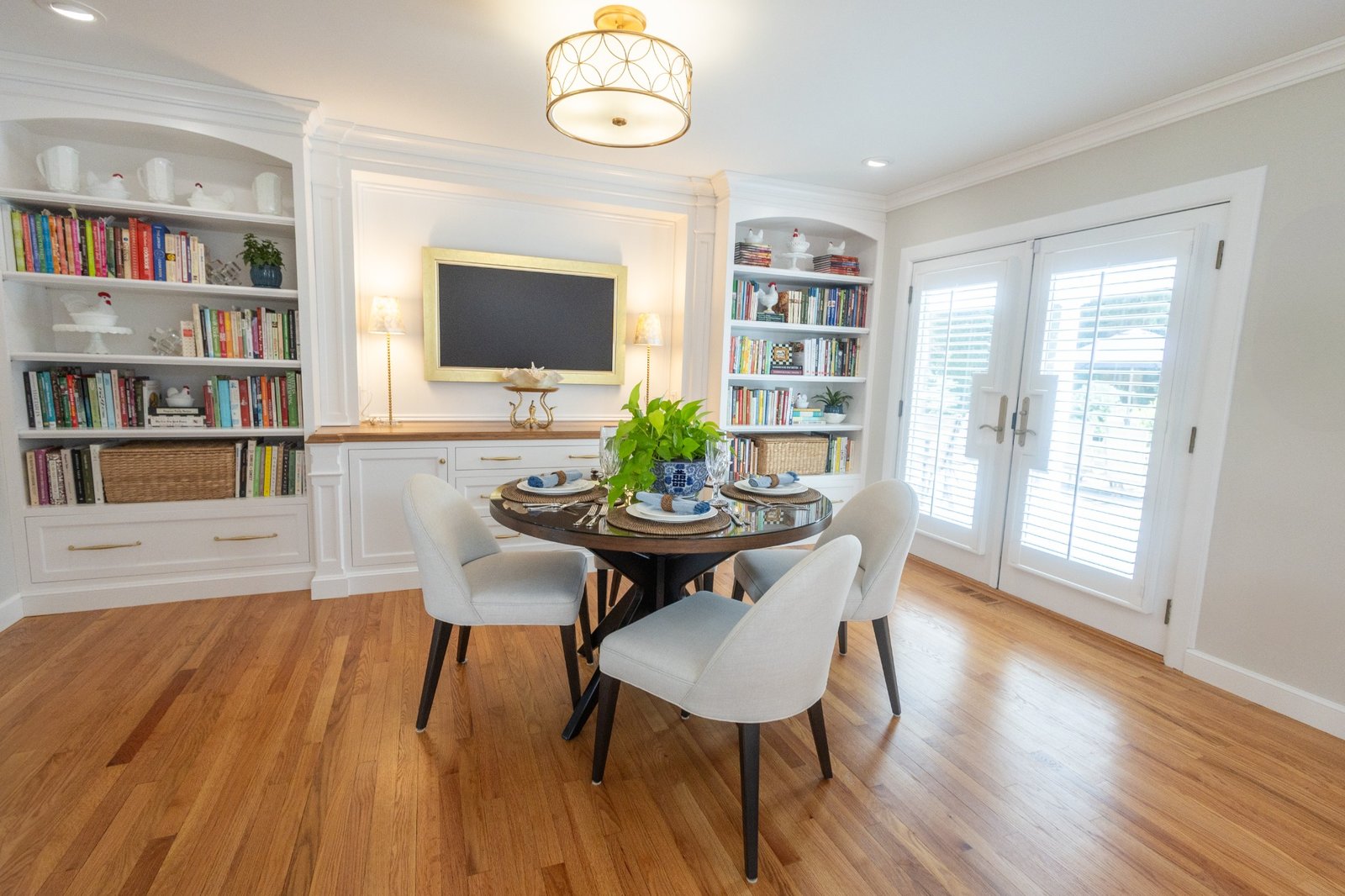 Custom entertainment cabinetry Cheshire CT featuring white cabinetry, built-ins, arched shelving, and warm wood counters in a dining and game room design.