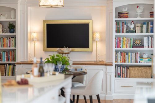 Custom entertainment cabinetry Cheshire CT featuring white cabinetry, built-ins, arched shelving, and warm wood counters in a dining and game room design.