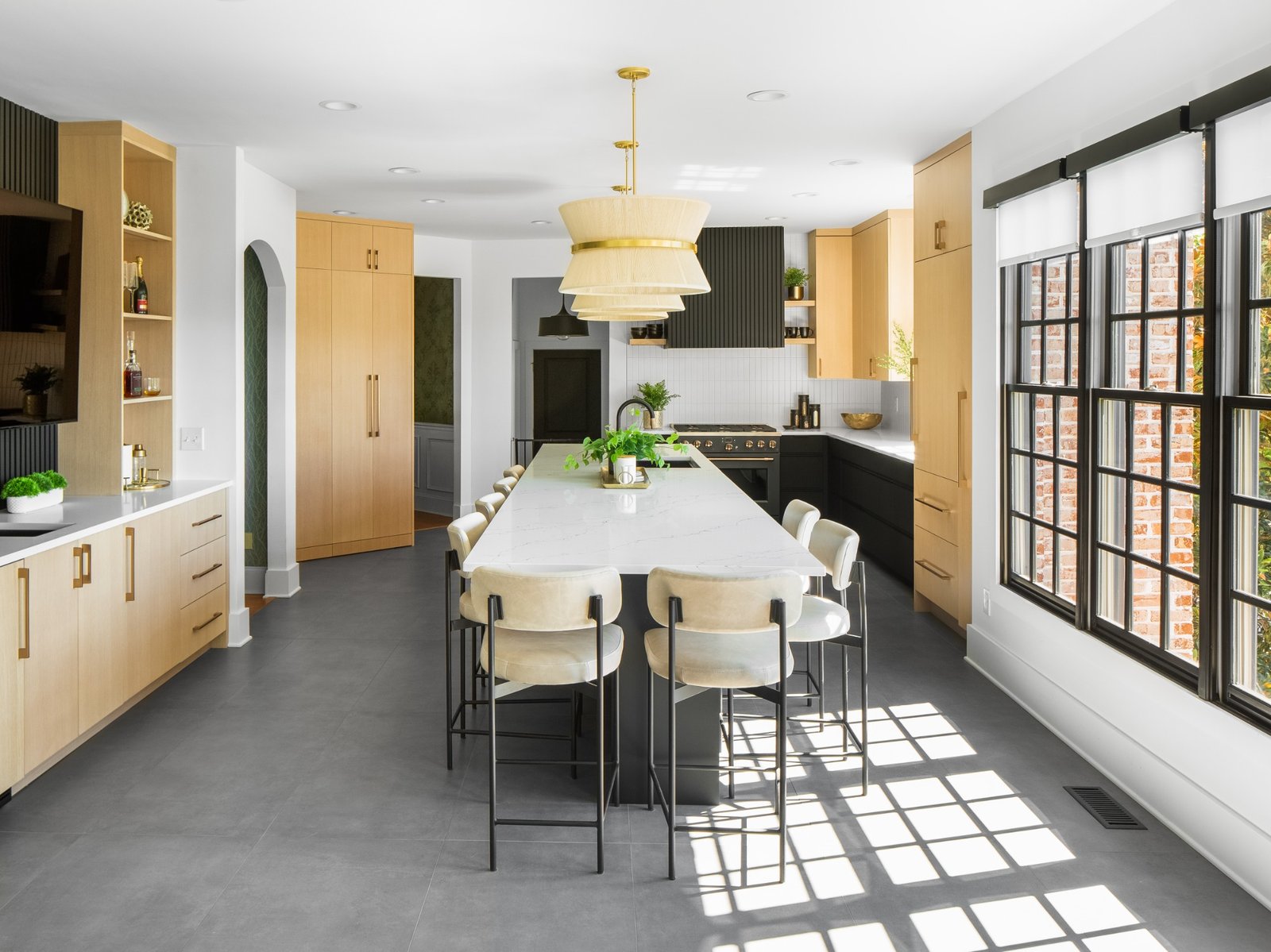 Custom kitchen cabinets Knoxville TN – wide view of kitchen with large island, light wood cabinetry, and black-framed windows.