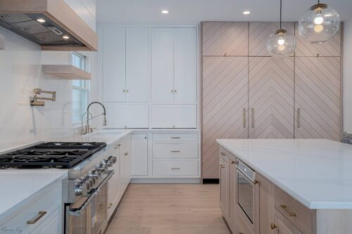 Custom Avalon NJ kitchen cabinetry featuring white maple perimeter cabinets, oak island with quartz top, and integrated refrigerator panels.