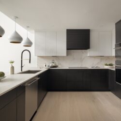 Contemporary kitchen remodel in Ludlow VT with custom cabinets, stainless steel appliances, and waterfall quartz countertop.
