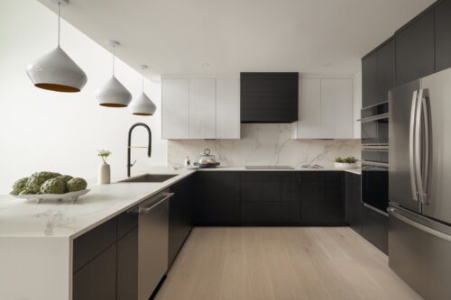 Contemporary kitchen remodel in Ludlow VT with custom cabinets, stainless steel appliances, and waterfall quartz countertop.