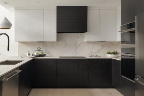 Two-tone kitchen cabinets in Ludlow VT with black base cabinetry, white upper cabinets, and integrated cooktop.