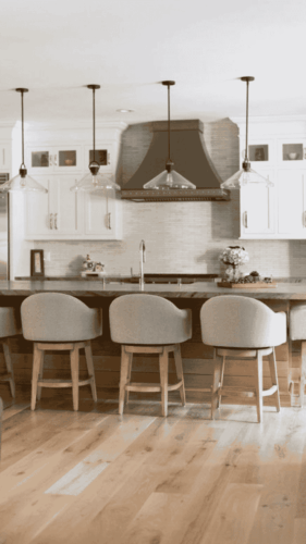 custom kitchen with white cabinets a custom metal range hood and a maple island