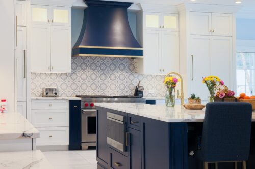 Custom kitchen cabinets in Nesconset NY with navy island, white perimeter, and marble countertops.
