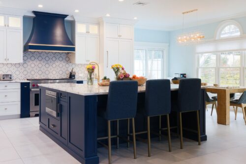 Nesconset NY kitchen design with navy and white custom cabinets, large island, and seating for three.