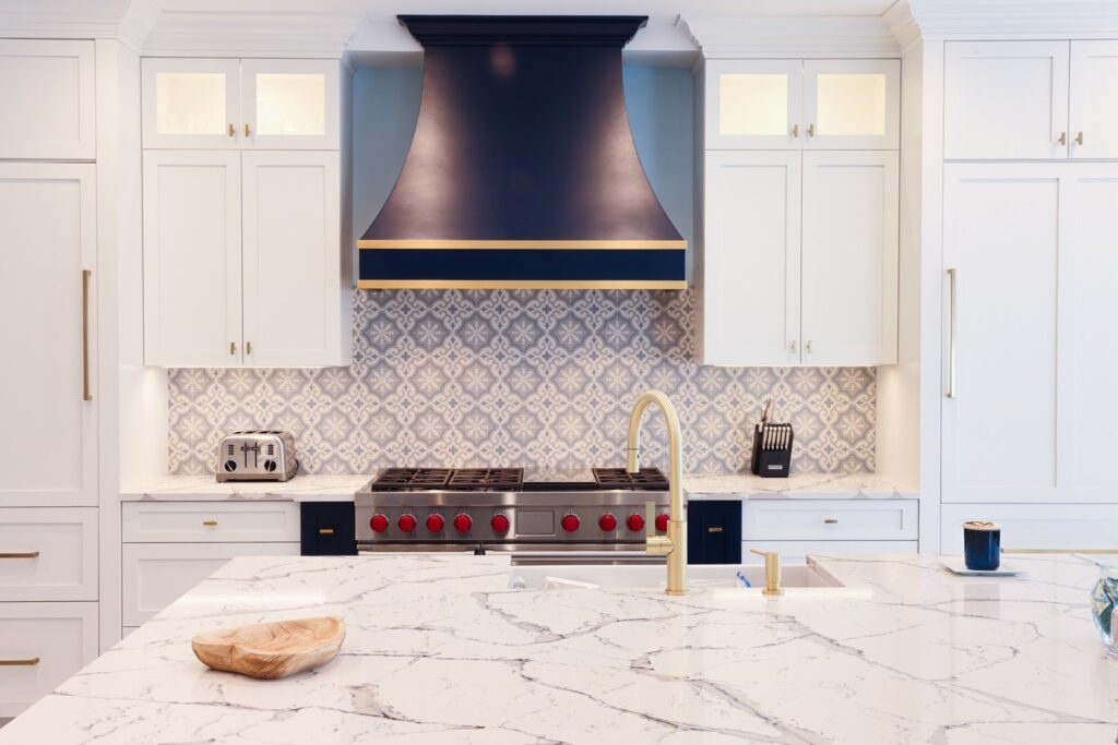Luxury kitchen cabinets in Nesconset NY featuring patterned backsplash, marble counters, and gold faucet. Luxury kitchen cabinets in Nesconset NY featuring patterned backsplash, marble counters, and gold faucet.