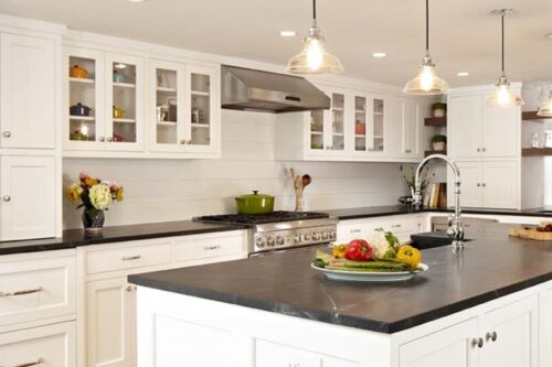Custom kitchen cabinets New Canaan CT with glass-front uppers, shiplap backsplash, pro range, and honed soapstone counters.