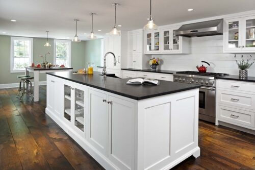 Modern farmhouse kitchen with white shaker cabinets, large island, pendant lights, and casual breakfast nook.