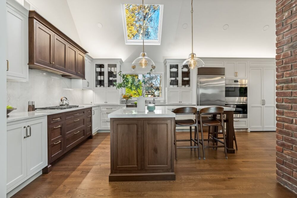 Custom kitchen Short Hills NJ with white perimeter cabinetry, walnut island and range hood.