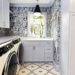 Annapolis laundry room with custom Blue Ice cabinets, long countertop for folding, windowed sink wall, and patterned wallcovering by Tina Colebrook Kitchens.