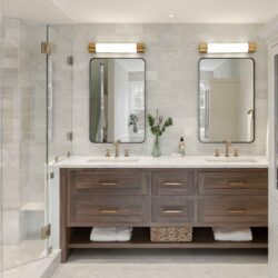 Wide view of an Exeter NH master bath remodel with custom walnut bathroom vanity, tall painted maple cabinet, and glass shower enclosure.
