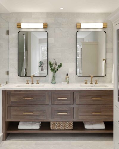 Front view of custom walnut bathroom vanity with double sinks, brass fixtures, and white countertops in an Exeter NH master bath remodel.