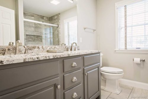 Bathroom featuring cinder painted cabinets with marble top and sink Wyomissing, PA